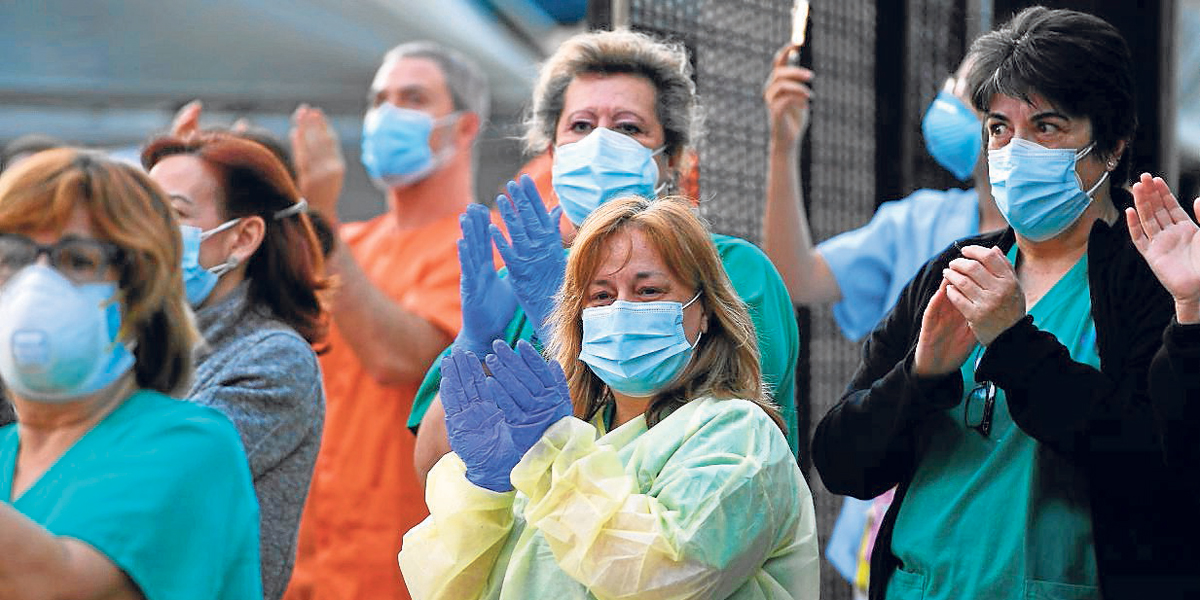 Los trabajadores de salud aplauden a cambio mientras son aplaudidos frente al Hospital Gregorio Maranon en Madrid el 12 de abril de 2020 durante un cierre nacional para prevenir la propagación de la enfermedad Covid-19.