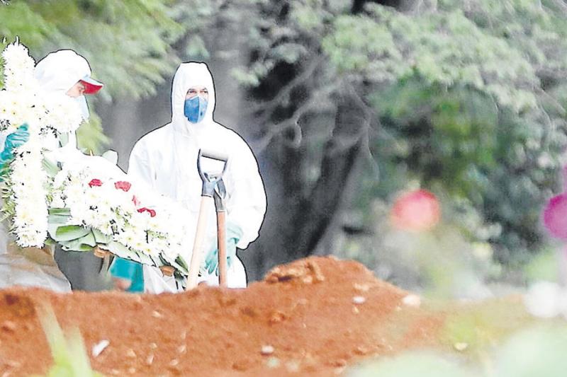 Empleados del servicio funerario entierran a una víctima de Covid-19 en el cementerio de Vila Formosa, situado en Sao Paulo, Brasil.