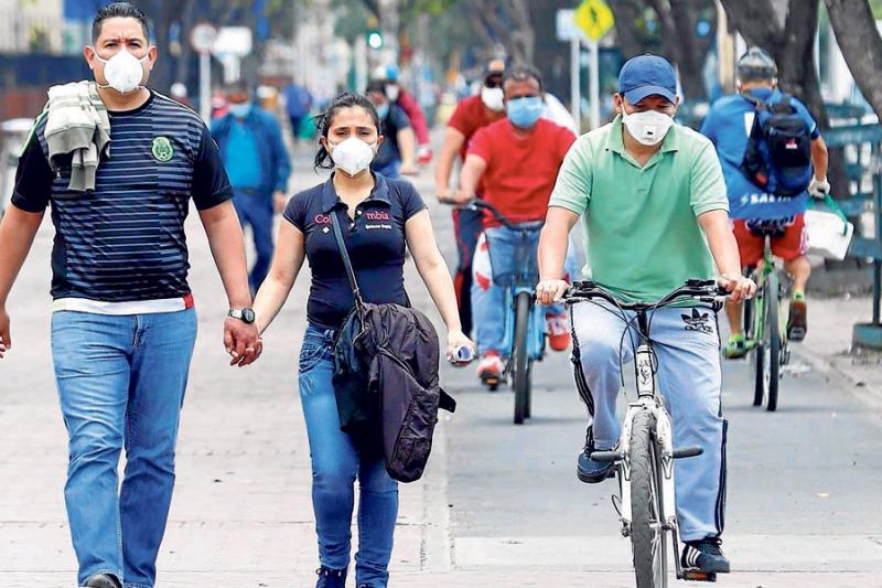 Una pareja camina en una calle este lunes en Bogotá. El país completó cuatro semanas en ‘cuarentena’ y aislamiento obligatorio para contener el avance del coronavirus que ya sumaba ayer 2.979 casos.