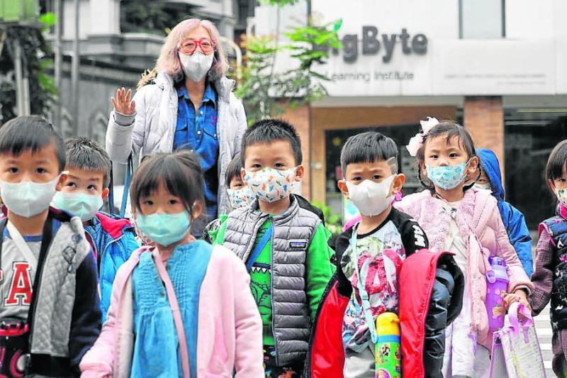 Niños estudiantes caminan en una calle de Taipei, capital de Taiwán, país que desató el escándalo de la OMS, al señalar que había alertado a esa entidad sobre el Covid-19 en diciembre del año pasado.
